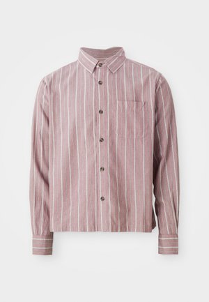 Sarkans un balts svītrots pogkrekls ar apkakli, garām piedurknēm un priekšējo kabatu. Izgatavots no teksturētas auduma ar mīkstu apdari.