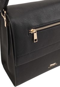 Zwart leren handtas met een gestructureerd oppervlak, voorzien van een gouden ritsvak en merkmateriaal. Compacte rechthoekige vorm met een gestructureerd ontwerp.
