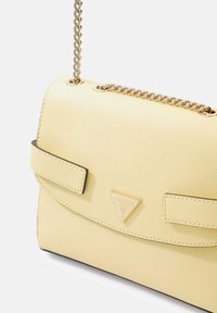 Borsa sintetica gialla con texture, con tracolla a catena, caratterizzata da un logo triangolare, due cinturini anteriori e base nera.