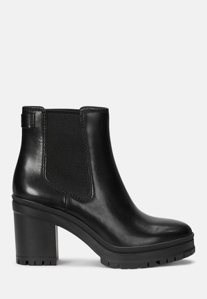 Bottine noire en cuir avec talon bloc épais, panneau latéral élastique et semelle texturée pour une bonne adhérence.
