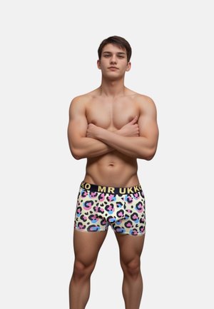 Farverige leopard-tryk bokser-shorts med en sort talje, der er mærket "MR UKKO." Stoffet ser glat og tætsiddende ud, hvilket fremhæver en atletisk krop.
