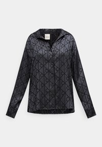 Fekete, gombos ing fényes anyagból, geometriai mintával, összefonódó vonalakkal. Bő szabású, hegyes gallérral és hosszú ujjakkal.