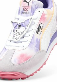 Puma Easy Rider sportbačiai su pasteliniais spalvotais, ryškiaspalviais piešiniais, pagaminti iš nubuko ir sintetinės medžiagos, su pieštuku primenančia charakterio pavadinimu pakabuku ir rožine padu.