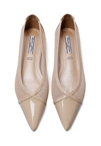 Scarpe piatte beige con punta affusolata, dotate di un cappuccio in pelle lucida e pannelli laterali in rete. Soletta etichettata "Vera Pelle" per la qualità della pelle.