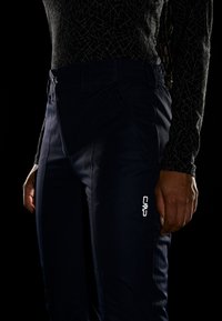 Marine udendørsbukser med elastisk talje, sidelommer med lynlås og reflekterende CMP-logo. Fremstillet af slidstærkt, glat stof med en tætsiddende pasform.