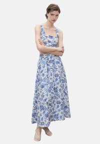 Blumen-Maxi-Kleid in Weiß mit blauen Mustern, mit einem quadratischen Ausschnitt, breiten Trägern und einer fließenden Silhouette. Weicher Stoffqualität.