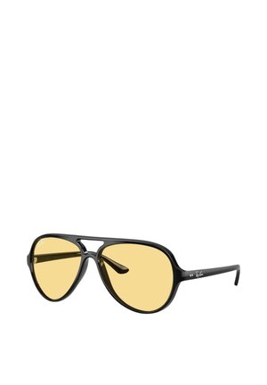 Lunettes de soleil aviateur à monture noire avec verres teintés jaunes et double pont, inclinées pour montrer les branches avec le logo Ray-Ban sur le côté.