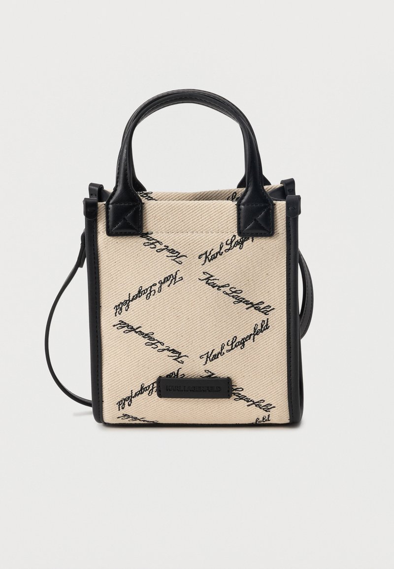 Μικρή μπεζ υφασμάτινη τσάντα tote με μαύρο κείμενο "Karl Lagerfeld", μαύρες δερμάτινες λαβές, επένδυση και ρυθμιζόμενο ιμάντα ώμου.