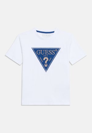 Camiseta blanca de manga corta con un logo triangular azul centrado, que presenta "GUESS U.S.A." y un gran signo de interrogación dentro del triángulo.