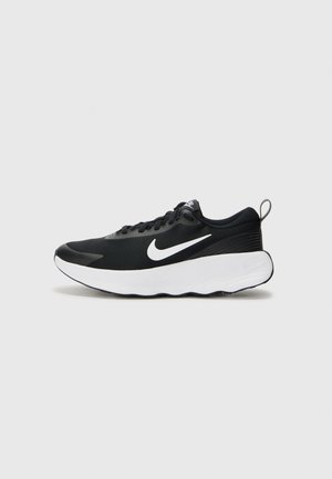 Schwarzer Sportschuh mit einem strukturierten Mesh-Obermaterial, flacher weißer Sohle und einem auffälligen weißen Swoosh-Logo. Verfügt über Schnürsenkel und eine Zuglasche.