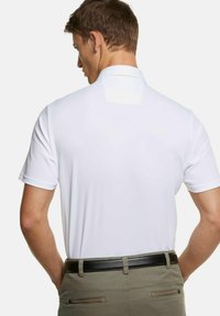 Witte polo met een geweven stof, korte mouwen en een klassieke kraag; gedragen met kaki broek en een zwarte riem, waarbij de achterkant te zien is.