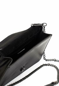 Bolso de mano de cuero negro con acabado mate, correa de cadena en tono plateado y cierre a presión negro. El interior cuenta con un suave forro negro.