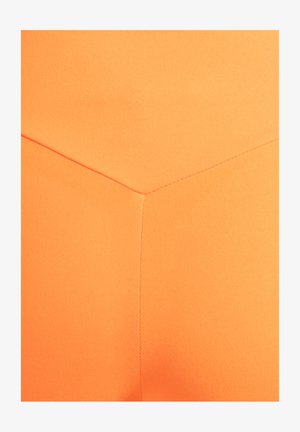 Pomarańczowa tkanina sportowa o gładkiej fakturze z wzorem szew w kształcie jodełki. Brak widocznych elementów metalowych lub wzorów.