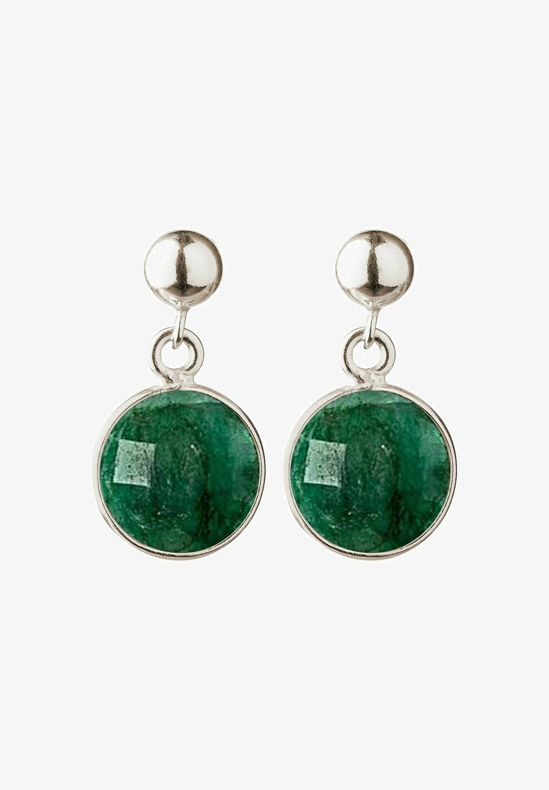 Boucles d’oreilles clous en argent avec pendentifs en pierre verte polie et ronde suspendus sous les clous sur fond blanc.