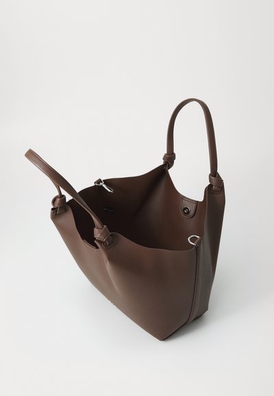 Sac en cuir marron avec deux poignées et un clip pour porte-clés à l'intérieur, photographié sur un fond blanc uni.