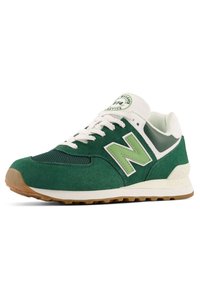 Baskets New Balance vertes et blanches avec dessus en daim et mesh, lacets blancs, semelle en gomme et patch logo sur la languette et le côté.
