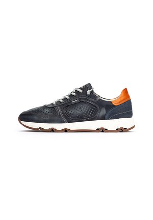 Zapatilla de cuero azul marino con detalles perforados, suela blanca, cordones grises y acento en el talón naranja, vista de perfil derecho en fondo blanco.