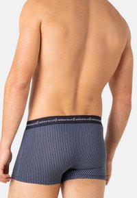 Boxers bleu marine avec un motif géométrique, dotés d'une taille noire portant l'inscription "Eminence", texture lisse et design ajusté.