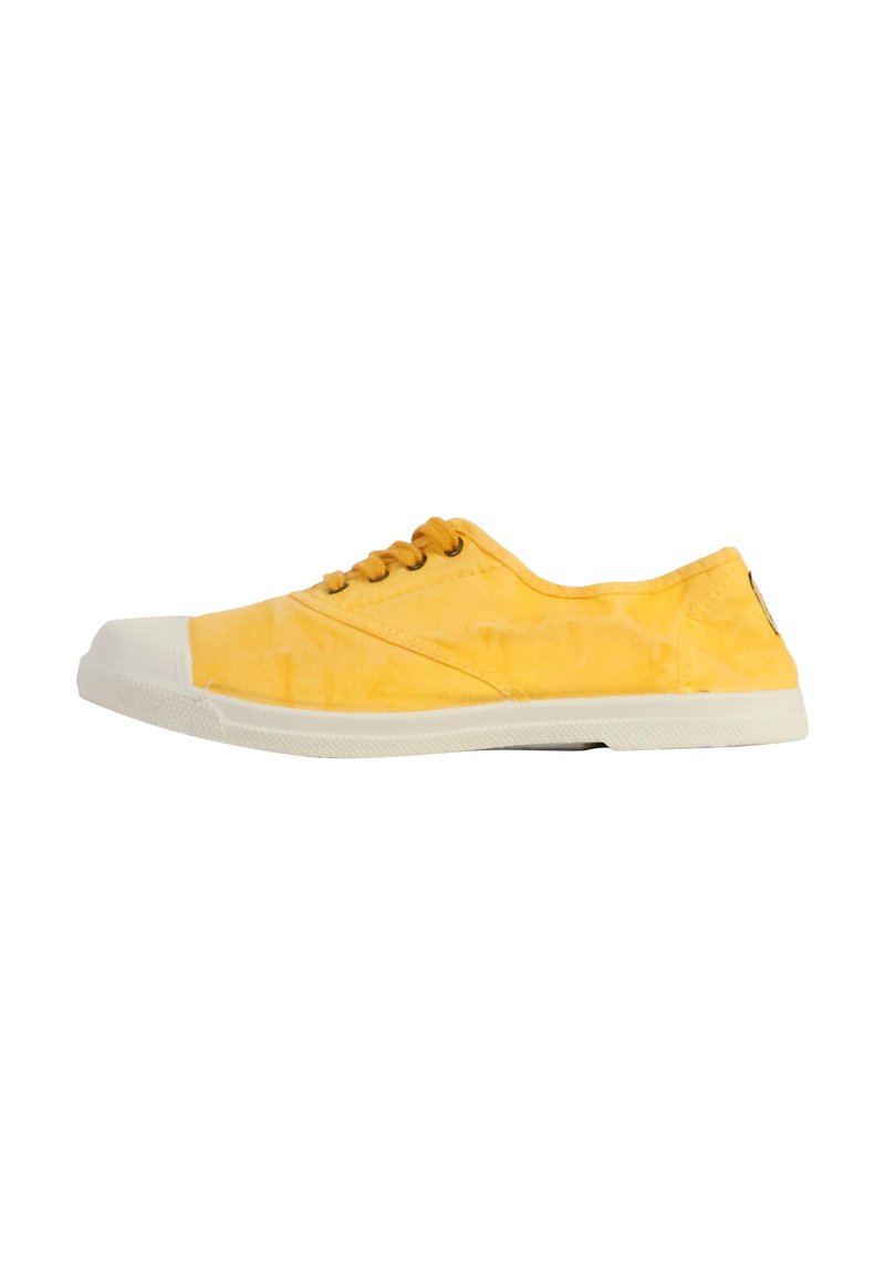 Zapatillas de lona amarillas con una puntera y suela de goma blanca. Presentan cordones redondos y detalles de costura, con una textura suave.