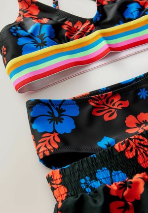 Ensemble de maillot de bain deux pièces présentant une base noire avec des motifs floraux colorés en bleu et rouge. Le haut comporte un bandeau multicolore à rayures ; taille élastique sur le bas.