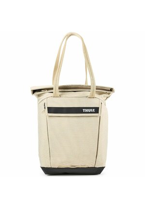 Beige Thule Tragetasche mit zwei Griffen, vorderer Reißverschlusstasche und schwarzem Boden auf weißem Hintergrund.