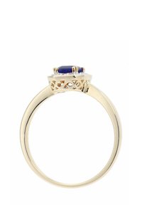 Zlatý prsteň s obdĺžnikovým modrým kameňom uprostred, zložitým filigránovým zdobením okolo puzdra, hladkým lesklým oblúkom.