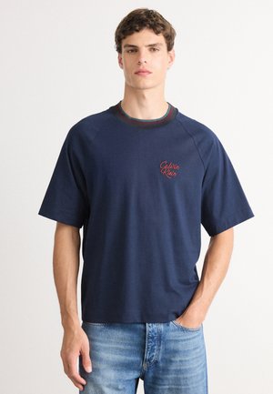 Námornícky modré bavlnené tričko s krátkymi raglánovými rukávmi, s okrúhlym výstrihom s farebným akcentom a vyšívaným logom "Calvin Klein".