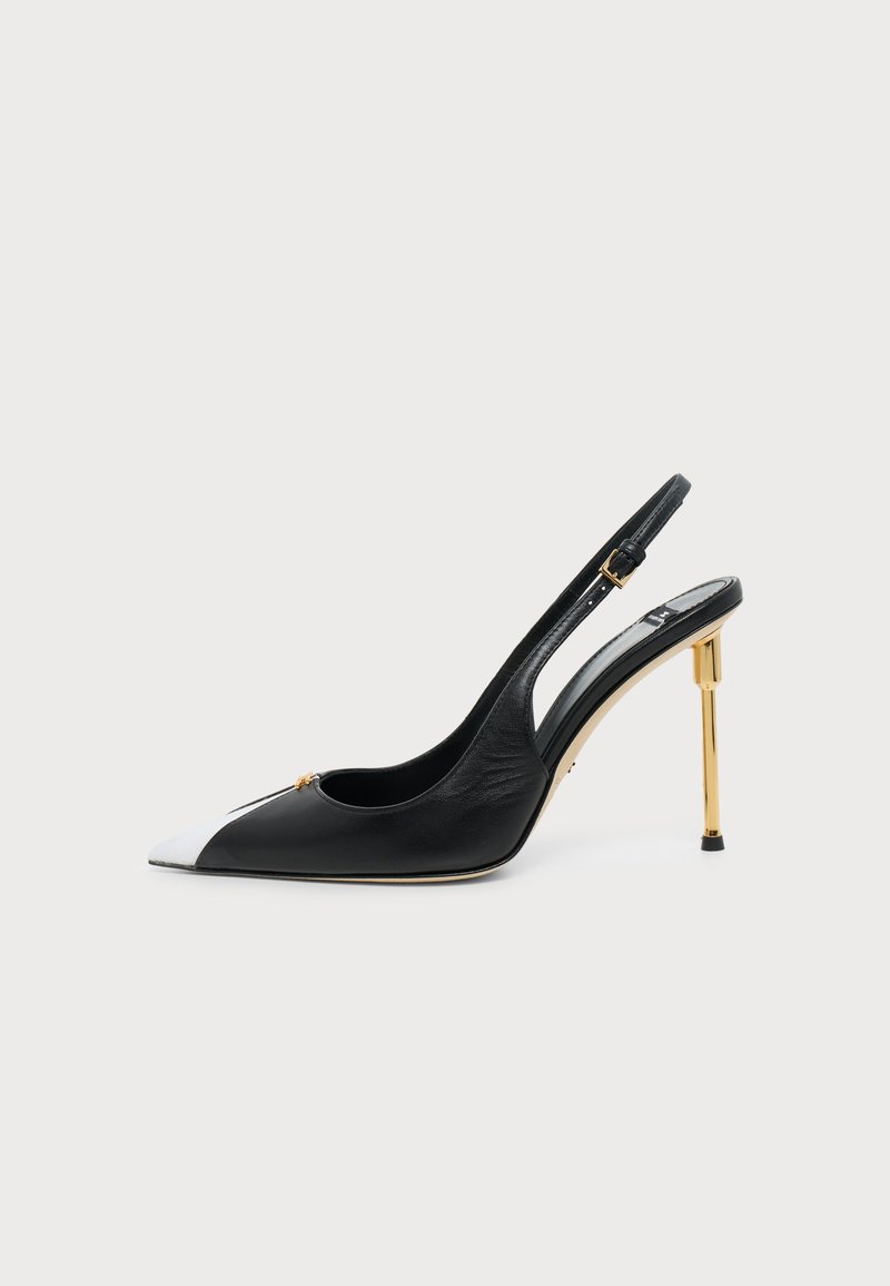 Μαύρο και άσπρο μυτερό γοβάκι slingback με ψηλό τακούνι στιλέτο σε χρυσό και μικρή αγκράφα στο λουράκι.