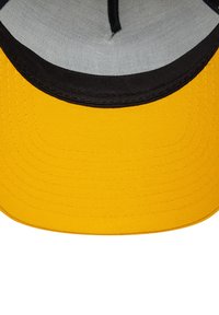 Gorra amarilla con visera plana y costuras negras. Interior forrado con tela gris. Presenta una cinta para el sudor circular en la parte superior.