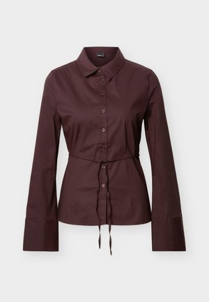 Σκούρο καφέ μακρυμάνικο πουκάμισο με κουμπιά, γιακά, ζώνη με κορδόνι στη μέση και φαρδιές μανσέτες, παρουσιάζεται σε ουδέτερο φόντο.