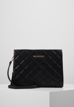 Black quilted leather handbag with a rectangular shape, gold logo accent, and a detachable shoulder strap. Smooth texture and compact design.