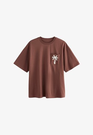 Brun bomulds-t-shirt med rund hals og korte ærmer. Har en hvid palme træ broderet på brystlommen.