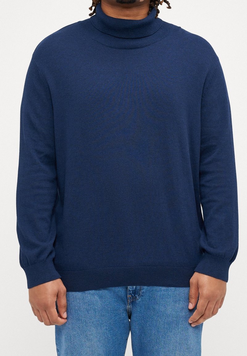 Mörkblå turtlenecktröja i fint stickat material, med ribbade detaljer vid halsen och ärmkanterna, i en avslappnad passform.