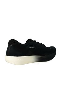 Scarpa sportiva nera con una tomaia texturizzata, dettagli neri lisci e una suola bianca con sfumature. Presenta un design con lacci e un branding minimale.