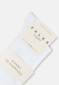 Két pár fehér Falke Happy pamutzokni UK 2½-5, EU 35-38, US 5-7½ méretben, csomagolási címkékkel.