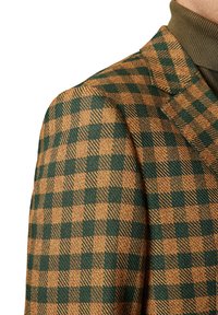 Brązowa i zielona marynarka w kratę z teksturowanej tkaniny. Posiada klapę typu notched oraz dopasowany krój, odsłaniający część kołnierza.