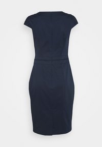 Robe ajustée bleu marine avec des manches courtes, un col rond et une couture à la taille discrète. Tissu lisse et coupe à hauteur des genoux. Fermeture éclair au dos.