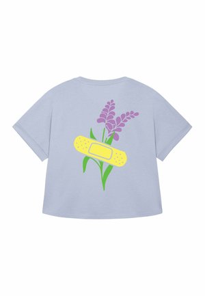 Svetlomodré tričko s grafikou fialových kvetov a žltým obväzom, ktorý vytvára hravý a umelecký dizajn.