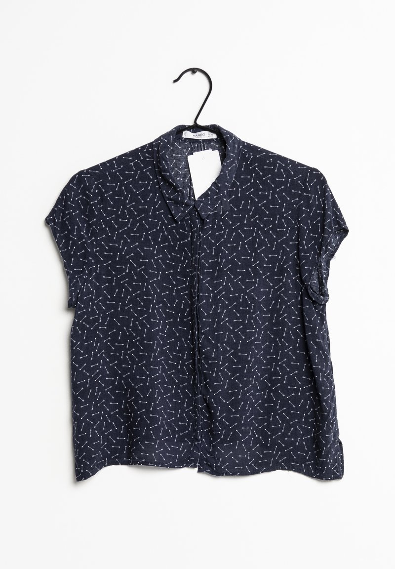 Blusa blu navy a maniche corte con colletto, caratterizzata da un modello geometrico bianco ripetitivo su tutto il tessuto. Esposta su un appendiabiti nero.