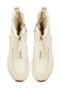 Botine crem cu un exterior neted, dotate cu un fermoar frontal, design capitonat și sole din cauciuc.