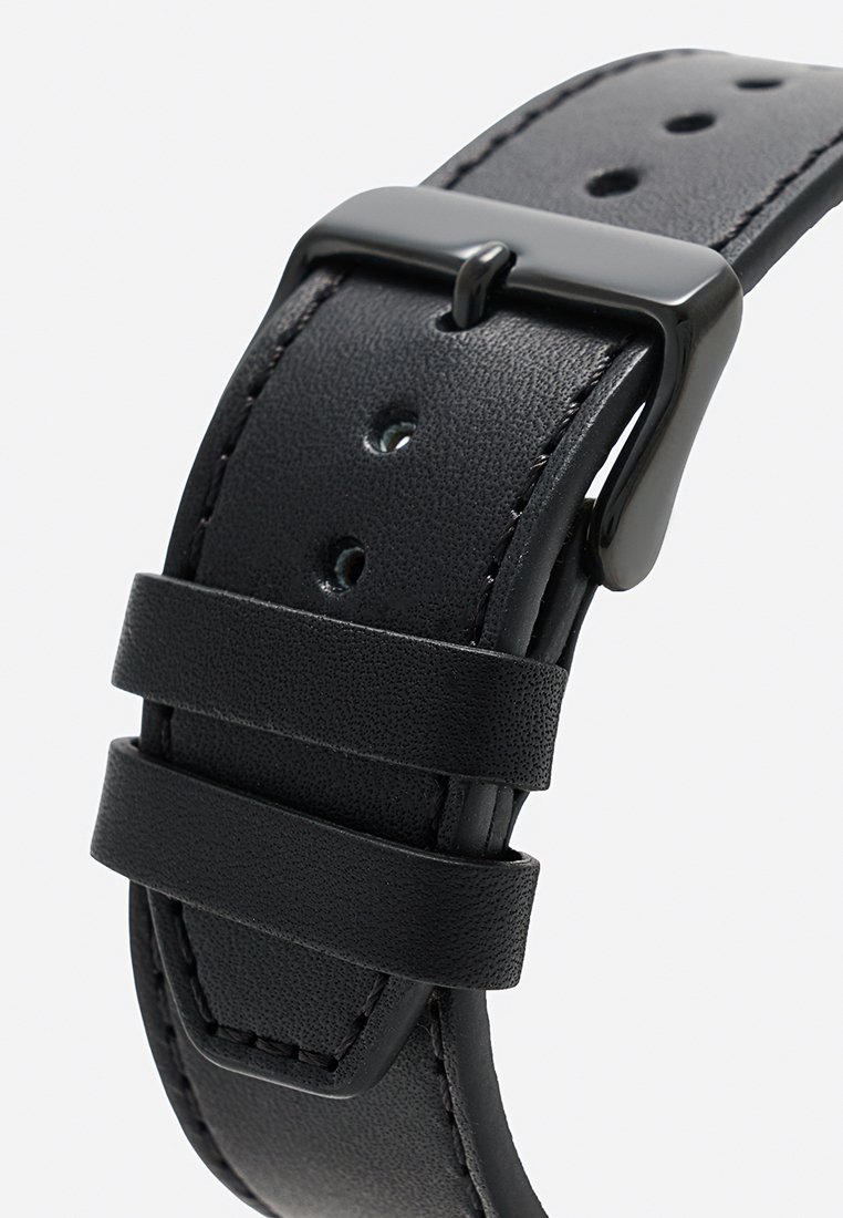 Correa de reloj de cuero negro con superficie texturizada, hebilla de metal negro pulido y tres agujeros ajustables para el tamaño.