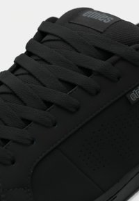 Μαύρα skate παπούτσια με υφή ματ φινιρίσματος, διαθέτουν στρογγυλά κορδόνια, τρυπητές λεπτομέρειες στο πλάι και λογότυπο στην γλώσσα.