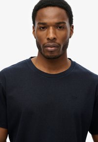 Marineblauwe T-shirt met ronde hals van katoen, met een subtiel logo op de borst, een gladde textuur en korte mouwen.