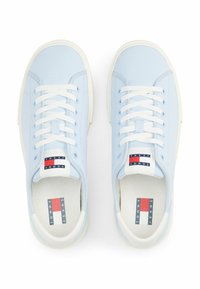 Jasnoniebieskie sneakersy o gładkiej skórzanej teksturze, białej gumowej podeszwie i kontrastującymi białymi sznurowadłami. Posiadają logo "Tommy Jeans".