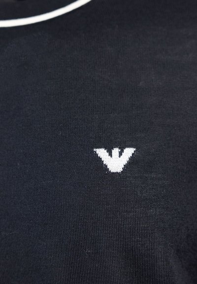 Maglietta nera a maglia con logo bianco sul lato sinistro del petto, dallo stile morbido e con scollo tondo.