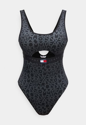 Bañador de una pieza gris oscuro con patrón de logo negro de "Tommy Jeans", banda con logo debajo del busto y abertura frontal debajo del pecho.