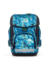 Sac à dos à motifs bleus et verts avec un accent requin. Dispose de plusieurs compartiments, de bandes réfléchissantes et d'une base solide.