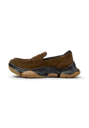 Brun ruskind loafer med tyk sort og tan chunky sål og slip-on design på hvid baggrund.
