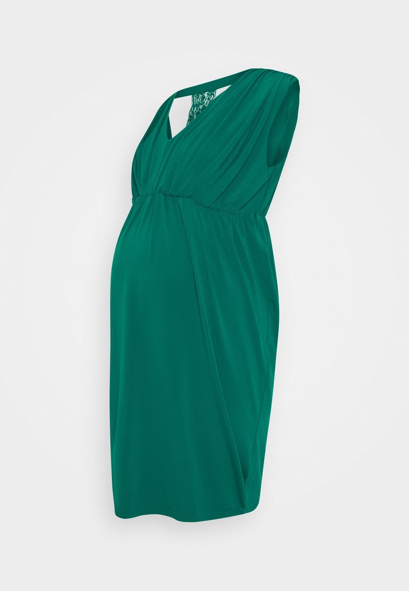 Sukienka ciążowa w leśnej zieleni, z miękkiego, zwisającego materiału, z dekoltem w kształcie litery V i koronkowym wykończeniem na plecach, o delikatnej sylwetce.