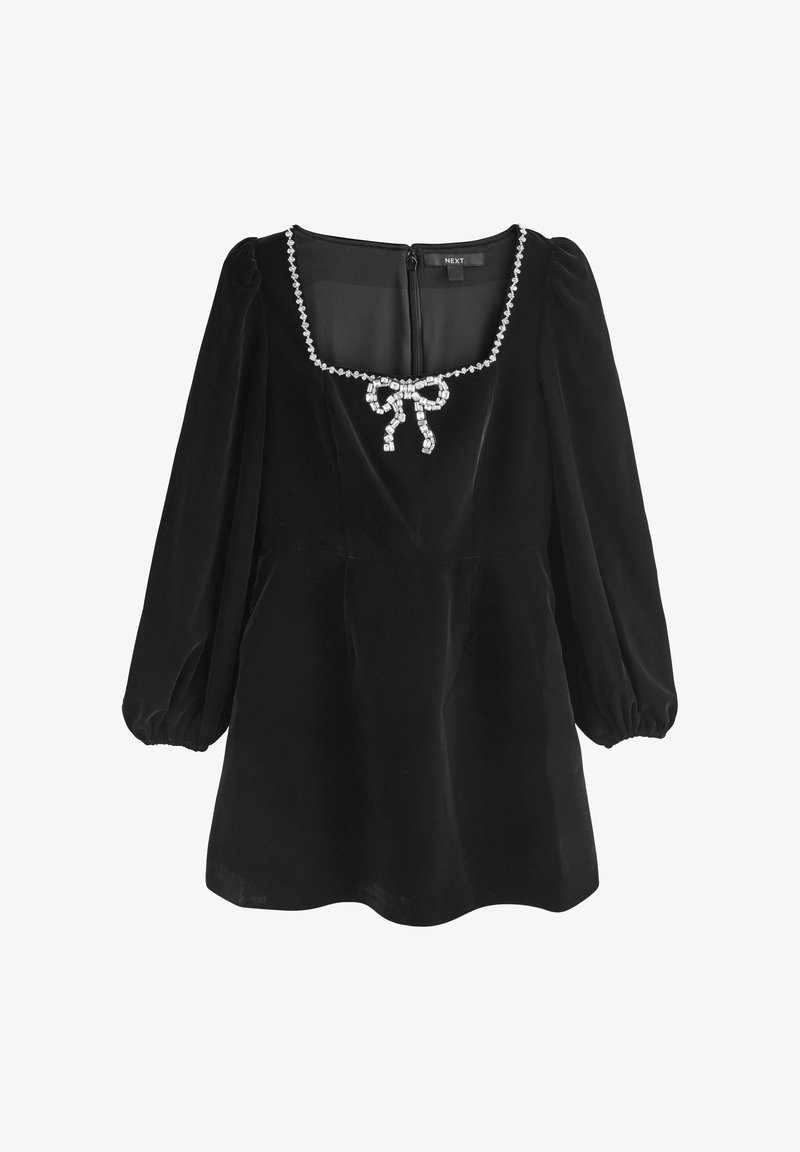 Rochie din catifea neagră cu decolteu pătrat, mâneci bufante și un detaliu decorativ sub formă de fundiță din cristale la față, având închidere cu fermoar la spate.